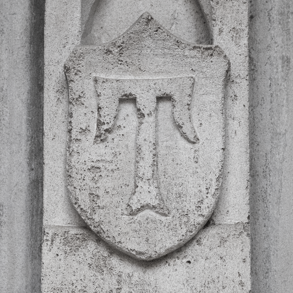 A decorative concrete tile on the side of Mitten Hall on Main Campus. At the center of the tile is the letter T.