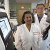 Lewis Katz School of Medicine researcher Anjali Rajadhyaksha collaborating with two colleagues in the lab