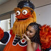 The Philadelphia Flyers mascot, Gritty, hugs a local student