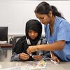 A Temple student working with a middle school student in a lab