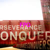 an image of the perseverance conquers sign on campus with the letters 'FPO,' for placement only