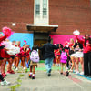 A teacher walking a student into school surrounded by Temple students and staff